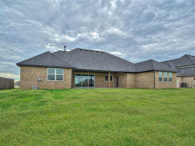 77 Orchid Ct, Piedmont, OK 73078 - back of house featuring a shingled roof, brick siding, and a yard