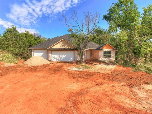 9070 Oak Tree Cir, Edmond, OK 73025 - ranch-style house with an attached garage and dirt driveway