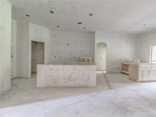 9070 Oak Tree Cir, Edmond, OK 73025 - kitchen featuring unfinished concrete floors, visible vents, and arched walkways
