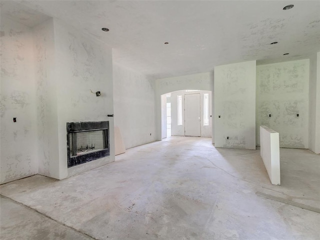 9070 Oak Tree Cir, Edmond, OK 73025 - unfurnished living room featuring concrete floors and a fireplace
