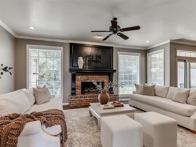 living area featuring crown molding, baseboards, recessed lighting, a brick fireplace, and a ceiling fan