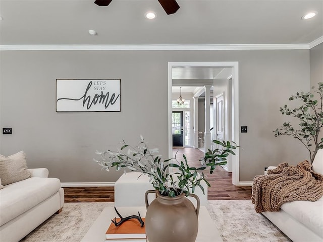 living area with recessed lighting, a ceiling fan, baseboards, ornamental molding, and wood finished floors