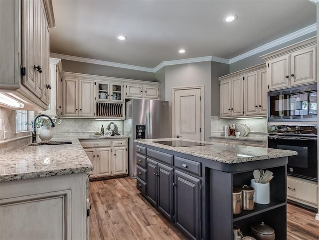 kitchen featuring tasteful backsplash, open shelves, a sink, a center island, and black appliances
