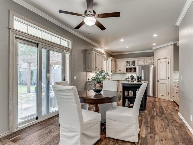 dining room featuring dark wood finished floors, ornamental molding, and ceiling fan