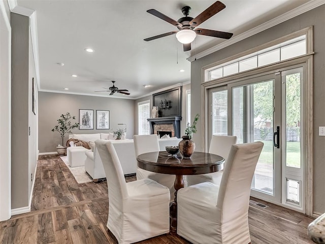 dining area featuring recessed lighting, a fireplace, a ceiling fan, visible vents, and ornamental molding