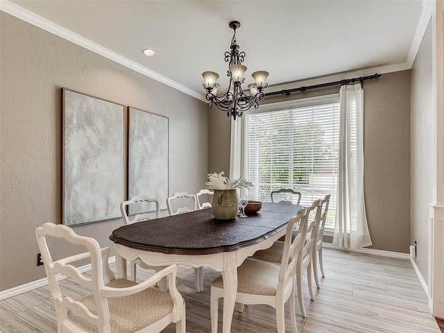 dining space featuring ornamental molding, light wood-style floors, a notable chandelier, and baseboards