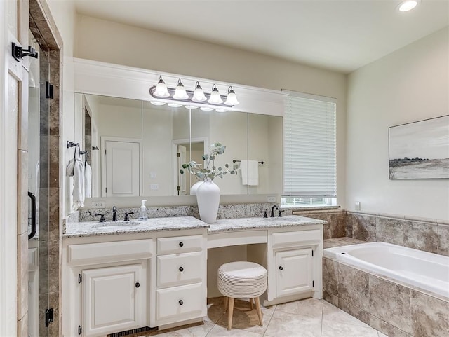 full bathroom featuring double vanity, a garden tub, recessed lighting, and a sink