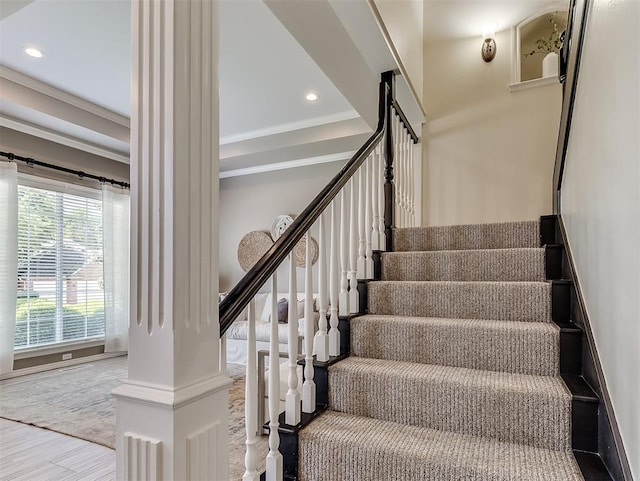 stairway with wood finished floors, crown molding, and recessed lighting
