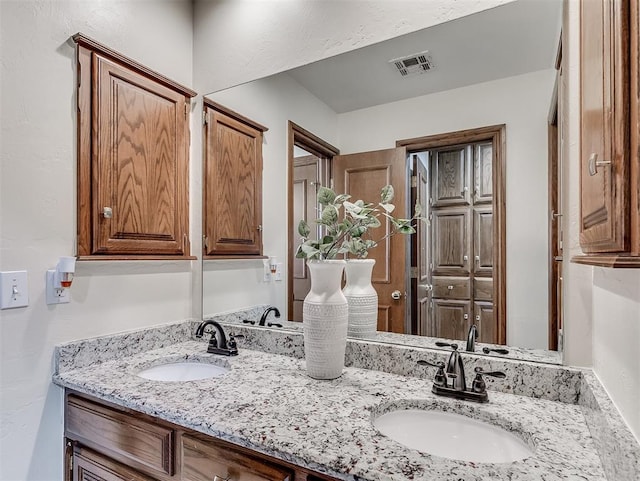 bathroom with double vanity, a sink, and visible vents