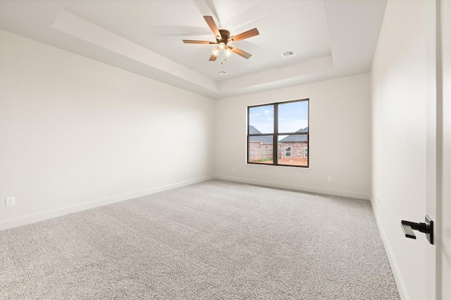 11713 NW 105th St, Yukon, OK 73099 - spare room featuring a raised ceiling, baseboards, light carpet, and a ceiling fan