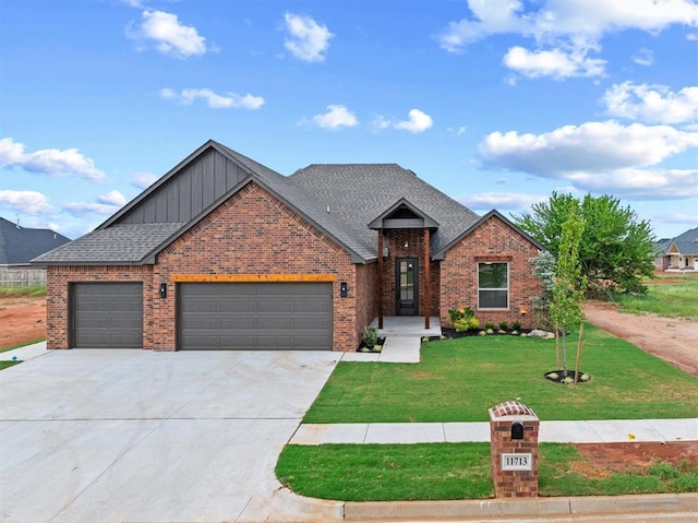 11713 NW 105th St, Yukon, OK 73099 - view of front of home featuring board and batten siding, brick siding, a front lawn, a garage, and concrete driveway