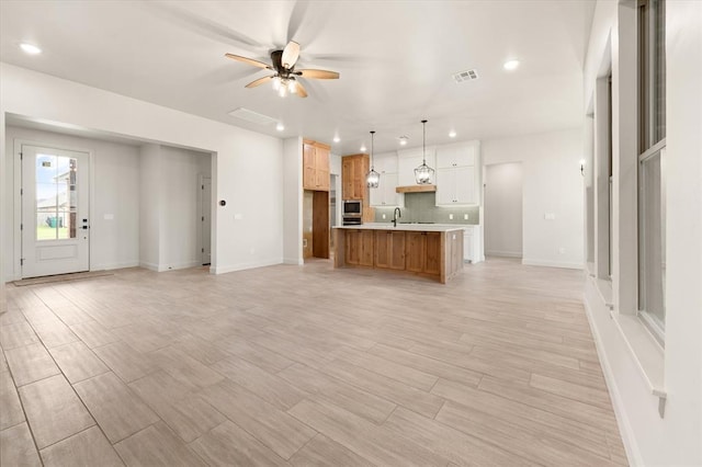 11713 NW 105th St, Yukon, OK 73099 - unfurnished living room with recessed lighting, ceiling fan, baseboards, a sink, and light wood finished floors