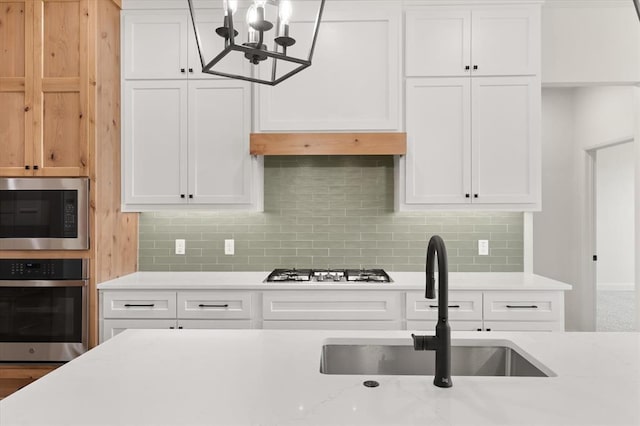 11713 NW 105th St, Yukon, OK 73099 - kitchen featuring stainless steel appliances, a sink, white cabinets, and decorative backsplash