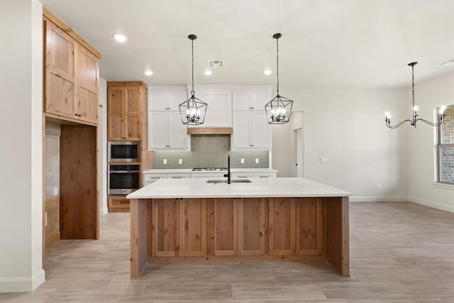 11713 NW 105th St, Yukon, OK 73099 - kitchen featuring stainless steel appliances, a chandelier, a sink, baseboards, and backsplash