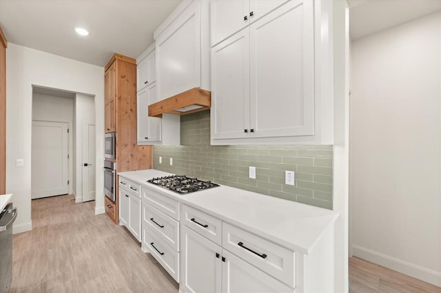 11713 NW 105th St, Yukon, OK 73099 - kitchen with stainless steel appliances, baseboards, light countertops, white cabinets, and light wood-style floors