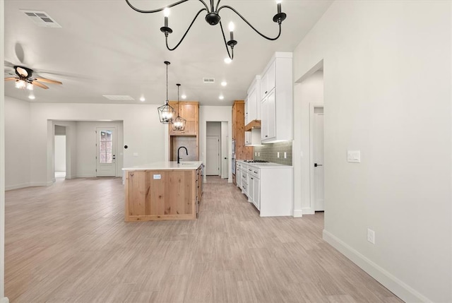 11713 NW 105th St, Yukon, OK 73099 - kitchen featuring a sink, open floor plan, light countertops, decorative backsplash, and a chandelier