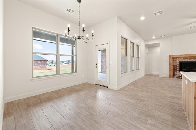 11713 NW 105th St, Yukon, OK 73099 - unfurnished dining area with a chandelier, light wood-style flooring, a fireplace, baseboards, and recessed lighting
