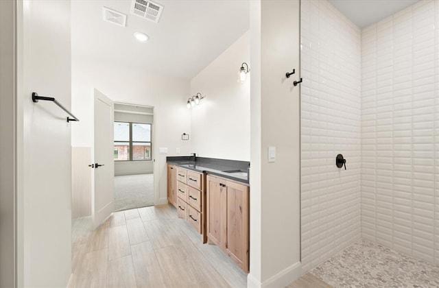 11713 NW 105th St, Yukon, OK 73099 - full bathroom with double vanity, a tile shower, wood finished floors, and baseboards