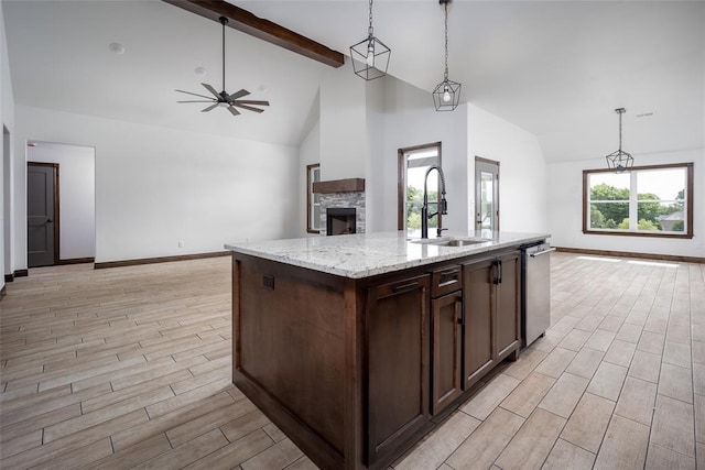 1431 County Road 2977, Blanchard, OK 73010 - kitchen with open floor plan, a stone fireplace, stainless steel dishwasher, ceiling fan, and light wood-type flooring
