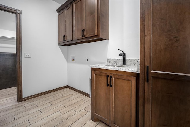 1431 County Road 2977, Blanchard, OK 73010 - washroom featuring electric dryer hookup, washer hookup, light wood-style flooring, and cabinet space