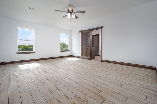 1431 County Road 2977, Blanchard, OK 73010 - empty room featuring a ceiling fan, a barn door, and light wood finished floors