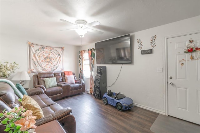 living area with baseboards, wood finished floors, and a ceiling fan