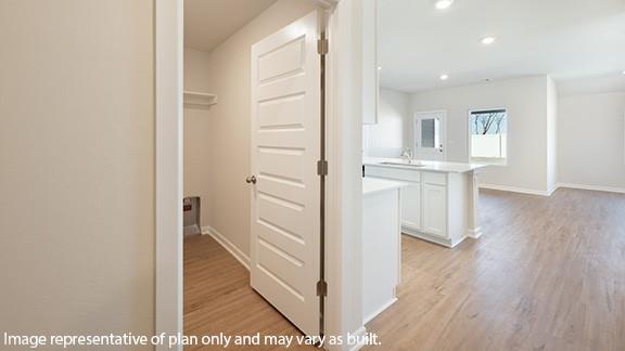 8313 NW 61st St, Oklahoma City, OK 73132 - hallway featuring recessed lighting, light wood-style floors, baseboards, and a sink