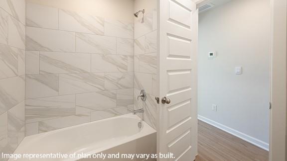 8313 NW 61st St, Oklahoma City, OK 73132 - bathroom with shower / tub combination, wood finished floors, and baseboards