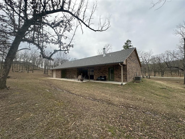114495 S 4296th Rd, Porum, OK 74455 - back of property featuring brick siding, a shingled roof, central air condition unit, and a patio area