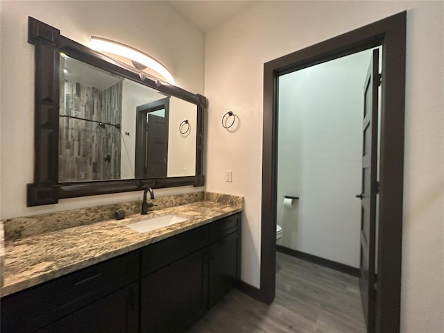 114495 S 4296th Rd, Porum, OK 74455 - full bathroom featuring a shower, baseboards, toilet, wood finished floors, and vanity