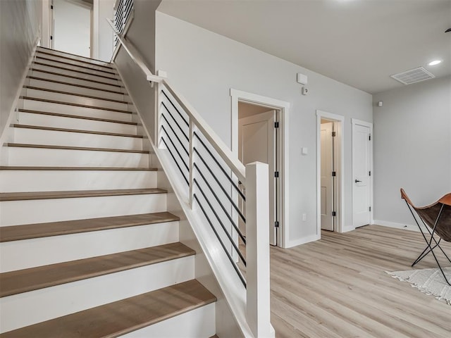 stairs with wood finished floors, recessed lighting, baseboards, and visible vents