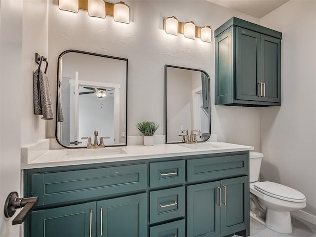 full bathroom with a ceiling fan, toilet, a sink, and double vanity