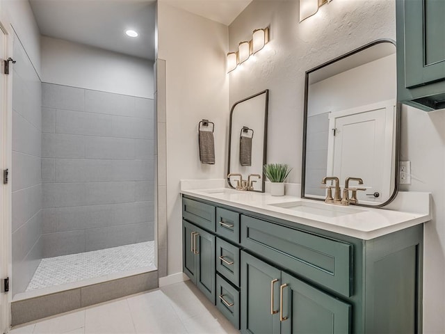 full bathroom featuring double vanity, a sink, a tile shower, and tile patterned flooring
