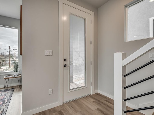 entrance foyer featuring plenty of natural light, baseboards, stairway, and wood finished floors
