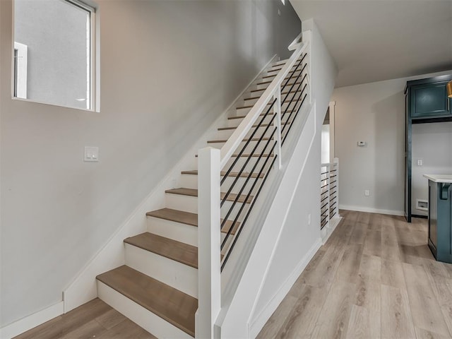 stairway featuring baseboards and wood finished floors