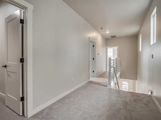 carpeted spare room featuring baseboards and visible vents