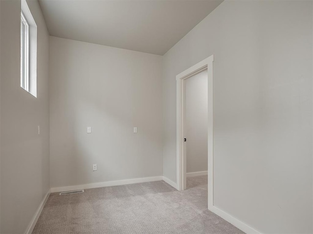 unfurnished room featuring light carpet, baseboards, and visible vents