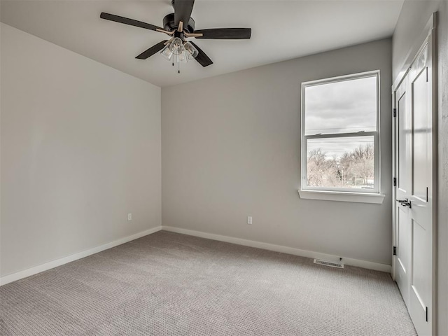 unfurnished room featuring baseboards, visible vents, ceiling fan, and carpet floors