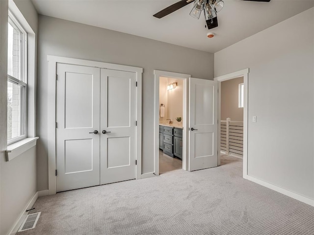 unfurnished bedroom featuring baseboards, visible vents, multiple windows, and light carpet