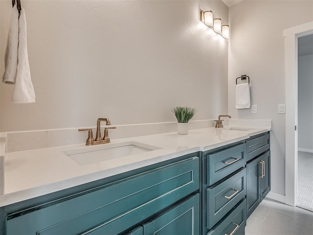 bathroom with baseboards, double vanity, and a sink