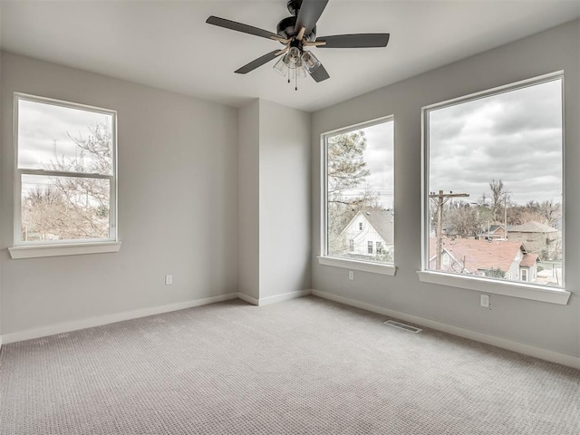 spare room featuring light carpet, baseboards, and visible vents