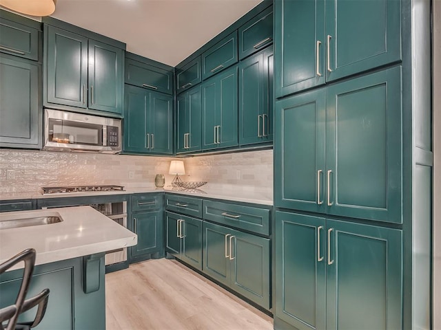 1308 NW 11th St, Oklahoma City, OK 73106 - kitchen with appliances with stainless steel finishes, green cabinetry, light countertops, and backsplash