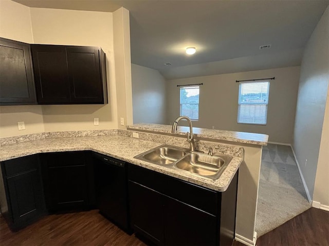 kitchen featuring a peninsula, light countertops, a sink, dark wood finished floors, and dishwasher