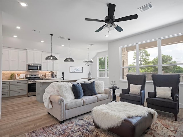 12712 NW 1st Ct, Yukon, OK 73099 - living room with light wood finished floors, recessed lighting, ceiling fan, and a chandelier