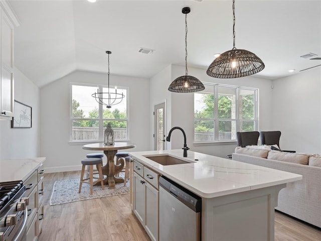 12712 NW 1st Ct, Yukon, OK 73099 - kitchen featuring stainless steel appliances, a sink, plenty of natural light, light wood finished floors, and lofted ceiling