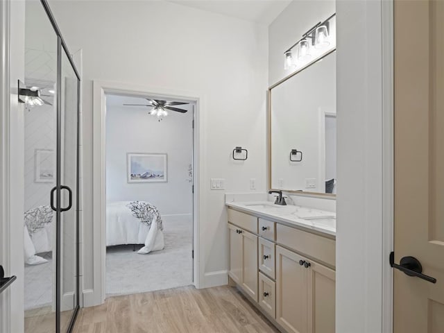 12712 NW 1st Ct, Yukon, OK 73099 - ensuite bathroom with double vanity, ceiling fan, wood finished floors, a shower stall, and baseboards