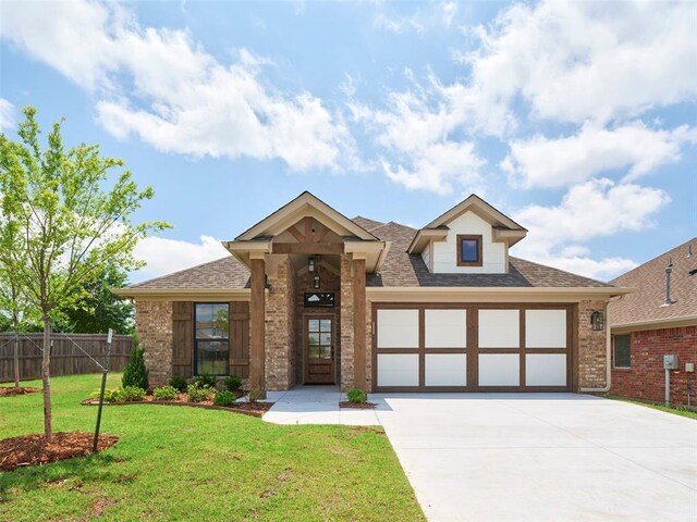 12712 NW 1st Ct, Yukon, OK 73099 - view of front facade featuring driveway, brick siding, an attached garage, and a shingled roof