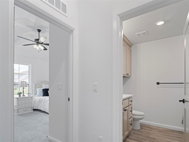 12712 NW 1st Ct, Yukon, OK 73099 - bathroom featuring vanity, ceiling fan, baseboards, toilet, and wood finished floors