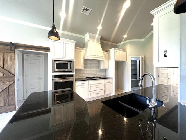 kitchen with appliances with stainless steel finishes, ornamental molding, a sink, premium range hood, and backsplash