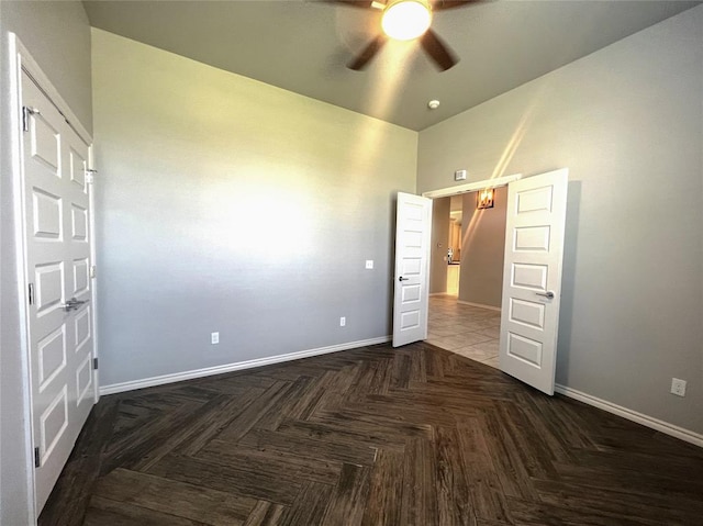 unfurnished bedroom with baseboards, ceiling fan, and a towering ceiling